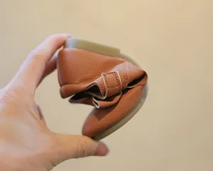 Nahaufnahme der flexiblen weichen Sohle brauner Leder-Slipper für Kleinkind-Mädchen