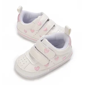 Vista dettagliata di scarpe da ginnastica bianche per neonati con cuori rosa ricamati