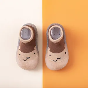 Draufsicht auf Cartoon-Babylauflernschuhe mit braunem Strick und weichen Gummisohlen