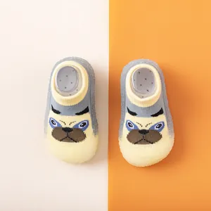 Detailaufnahme von gestrickten Babylauflernschuhen mit Bulldoggen-Motiv und Gummisohle