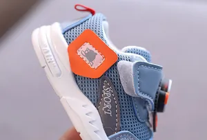 Dettaglio della scarpa da ginnastica in mesh blu per neonati con accenti arancioni.
