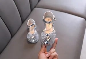 Zapatos de princesa plateados para niña con lazo de malla y detalle de perlas.