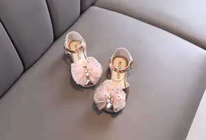 Vista detallada de zapatos de princesa oro rosa con lazo de malla y perlas