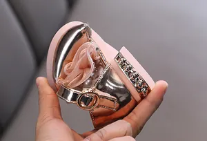 Detalle de zapato de princesa para niña en rosa metalizado con decoración de flores