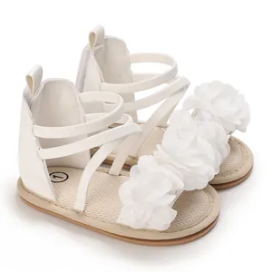 Vista dettagliata dei sandali bianchi per neonata con delicate decorazioni floreali