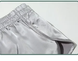 Detail shot of men's silver grey silky satin boxer shorts showing waistband and texture.