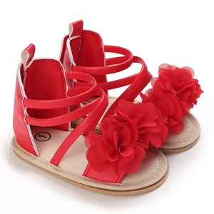 Dettaglio di sandali rossi per neonata con petali di fiori 3D decorativi a strati