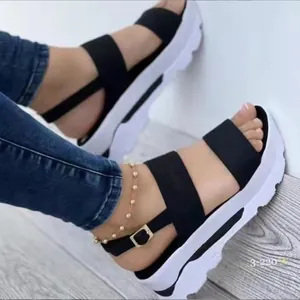 Vue détaillée de sandales compensées noires avec brides à boucle et semelles blanches