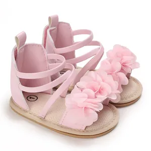 Dettaglio dei sandali rosa per neonata con fiori in chiffon 3D e soletta in rete morbida.