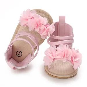 Dettaglio ravvicinato di sandali estivi rosa per neonata con grandi fiori in chiffon 3D