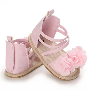 Dettaglio macro di sandali rosa per neonata con decorazioni floreali e suola in gomma