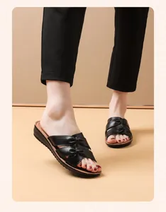 Primer plano de sandalias de cuero genuino negro con lazo y suela suave antideslizante