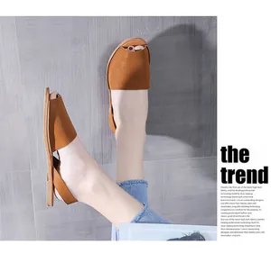 Detailed view of women's brown peep-toe flat sandals featuring a comfortable backstrap