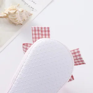 Detail view showing the anti-slip soft sole of a pink gingham baby princess pre-walker shoe