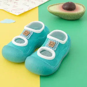 Macro detail of breathable turquoise baby walking shoes with cute cat patch.