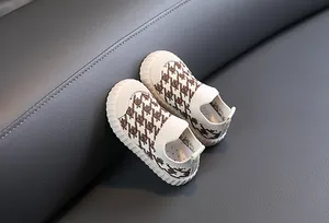 Detailed macro view of breathable children's mesh sneakers with brown houndstooth pattern.