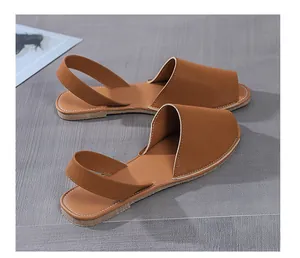 Detailed view of brown flat peep-toe sandals with back straps and contrast stitching