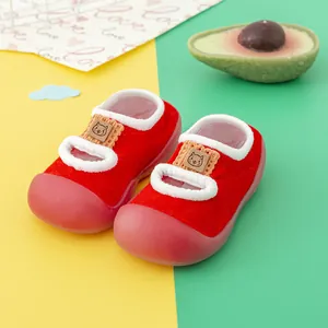 Detailed view of red infant walking socks with soft rubber soles and cat patch