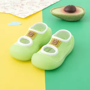 Close-up detail of lime green baby walker socks featuring soft rubber soles and cat patch