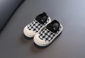 Detail of kids breathable mesh shoes with black and white houndstooth pattern knit upper.