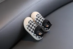 Detail of breathable children's sneakers with black and white houndstooth knit pattern