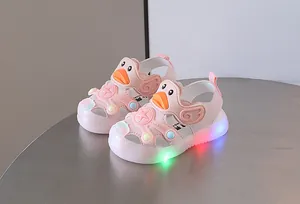 Close-up of pink toddler sandals featuring a cute duck design and glowing LED soles.