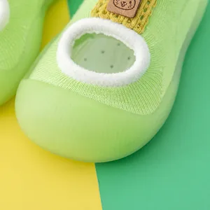 Close-up detail of green baby walking shoe featuring breathable knit and soft rubber toe