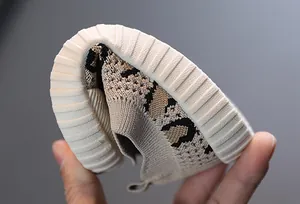 Close-up of flexible soft-sole baby toddler shoe with breathable knit leopard print.
