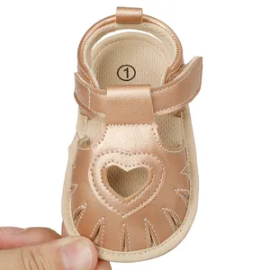 Close-up of rose gold baby summer sandals with heart-shaped cutout detail