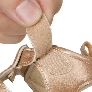 Close-up showing the adjustable hook-and-loop fastener on rose gold baby summer sandals