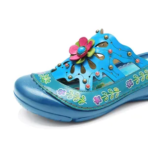 Gros plan sur chaussures en cuir bleu rétro faites main avec fleurs 3D et ajourés
