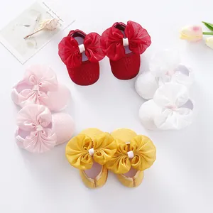 Detail of soft-soled baby princess shoes with large organza bows in multiple colors.