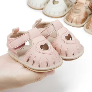 Close-up detail of soft pink baby summer sandals featuring cute heart cutout and velcro strap