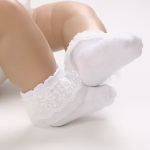 Close-up of white breathable mesh baby socks with delicate lace ruffles for infants