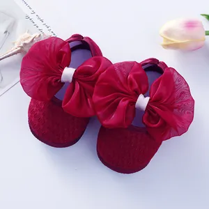 Detailed close-up of red infant princess shoes featuring elegant large mesh bows