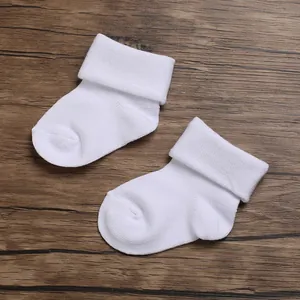Detailed view of breathable pure white cotton newborn socks with folded cuffs.