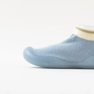 Gros plan d'une chaussure chaussette pour bébé avec semelle souple en silicone bleu