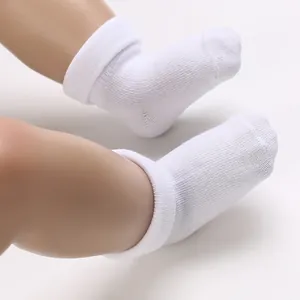Detailed macro view of breathable white cotton baby socks shown on newborn doll legs