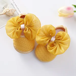 Yellow newborn baby princess shoes with large organza bow details, soft sole