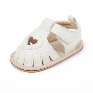 Detailed view of white baby heart cutout sandals with velcro strap and soft sole.