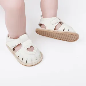 White infant summer sandals with heart-shaped cutout and Velcro strap for toddlers.