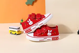 Close-up of red children's canvas shoes featuring cute rabbit and carrot prints