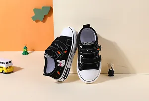 Close-up of black children's canvas shoes with cute rabbit and carrot patterns.