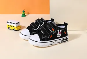 Detail of children's black canvas shoes featuring a cute bunny and carrot print