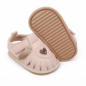 Detail showing the heart-shaped cutout and textured non-slip sole of pink baby sandals.