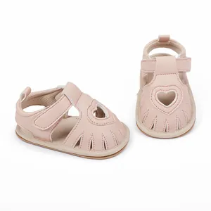 Detailed view of pink baby sandals with a heart cutout design and secure Velcro strap