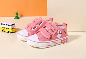 Detailed close-up of pink children's canvas shoes with cute rabbit and carrot patterns