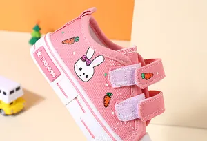 Close-up of pink children's canvas shoe with rabbit embroidery and velcro straps