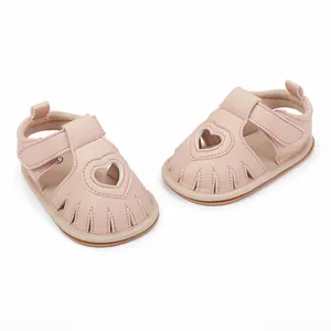 Close-up detail of pink baby sandals featuring heart cutout and adjustable Velcro strap