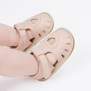 Detailed macro view of pink heart-cutout baby sandals for toddlers' first summer steps.